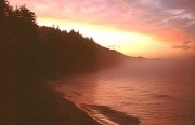 sunset beyond curving beach